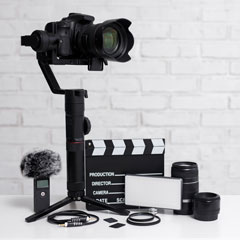 videography equipment against a brick wall